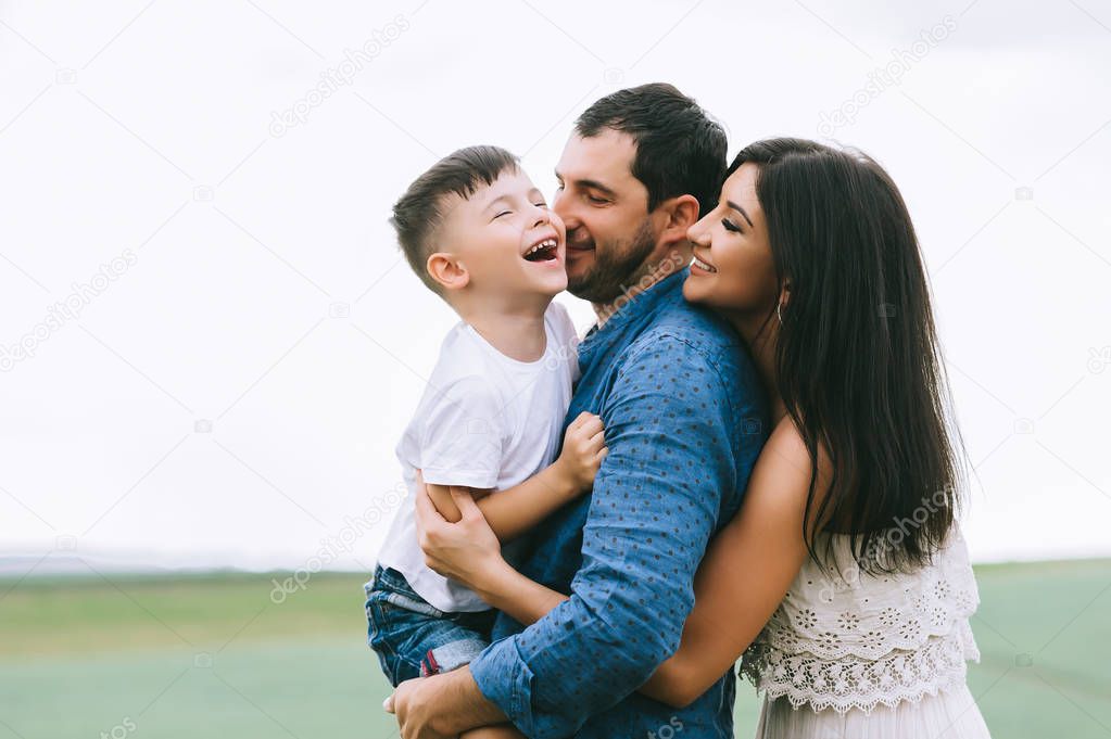 smiling parents and son having fun on field