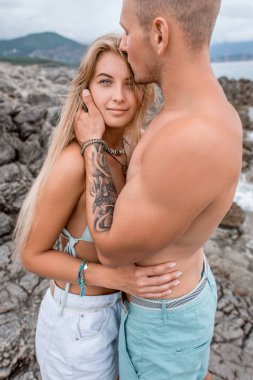 sarılma ve öpüşme güzel kız arkadaşı Karadağ kayalık plaj kas genç adam
