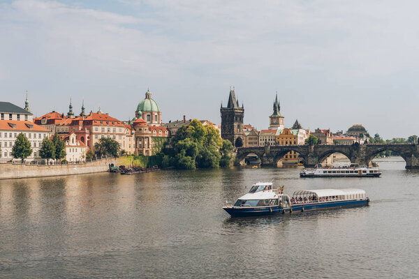 PRAGUE, CZECH REPUBLIC - JULY 23, 2018: famous charles bridge and boats on Vltava river in prague, czech republic