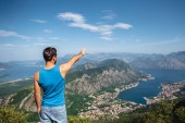 zadní pohled na člověka natáhl ruku pro kotorský záliv a město Kotor v Černé hoře