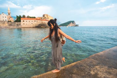 Budva, Karadağ için arka plan Stari Grad (Old Town) ile iskele tarafında yürüyen kadın 