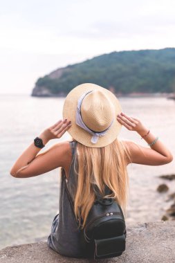 arkadan görünüşü şapka tutan ve Adriyatik Denizi Ricardova Glava Beach, Budva, Karadağ bakarak kadın