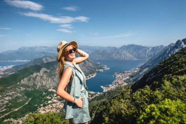 smiling woman posing with beautiful view on Kotor bay in Montenegro clipart