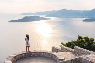 Budva, Karadağ için günbatımı sırasında Adriyatik Denizi yakınındaki bakış açısı üzerinde duran kadın