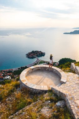 yüksek açı görüntülemek saint stephen ada Adriyatik Denizi, Budva, Karadağ yakın bakış açısı üzerinde duran kadın