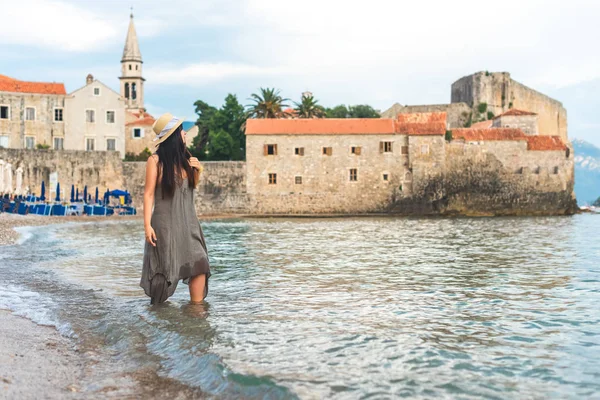 Adriyatik Denizi ile çan kulesi, Sveti Ivana Katedrali, Budva, Karadağ için arka plan üzerinde duran kadın