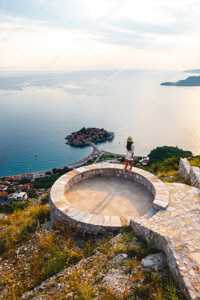 high angle view of woman standing on viewpoint near saint stephen island in Adriatic sea, Budva, Montenegro