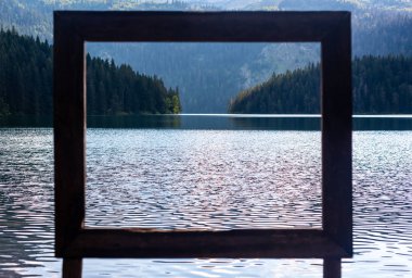 view through frame on beautiful glacial Black Lake in Montenegro clipart