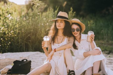 yere oturup kahve latte bardak ile zarif elbiseler güzel kızlar