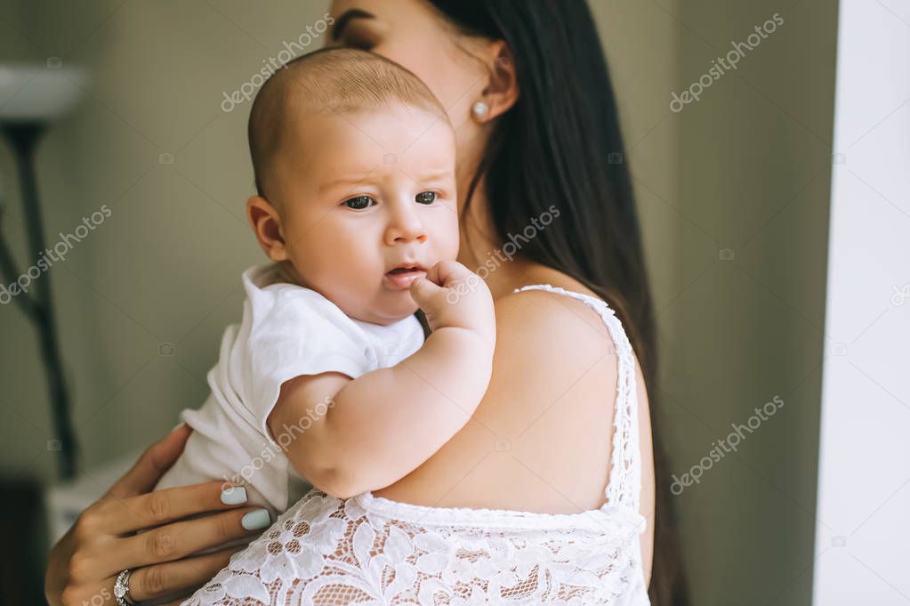 close-up portrait of mother carrying adorable little baby at home
