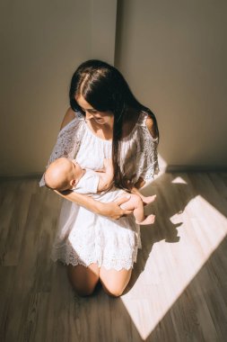 güzel anne bebek tutan ve evde yere çök ayakta
