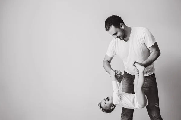 Foto em preto e branco do pai brincando junto com o pequeno filho em casa — Fotografia de Stock