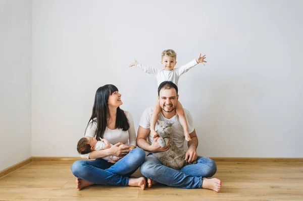 Familia feliz con dos hijos y gris británico taquigrafía gato en casa - foto de stock