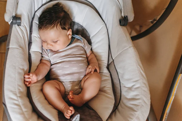 Vista aérea do bebê bebê em bodysuit branco dormindo no berço infantil — Fotografia de Stock