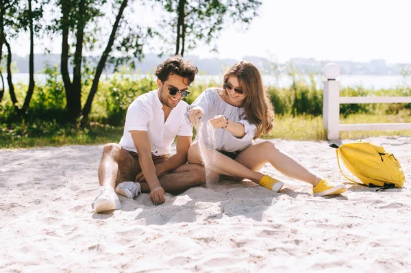 Feliz pareja jugando en la playa de arena de la ciudad - foto de stock