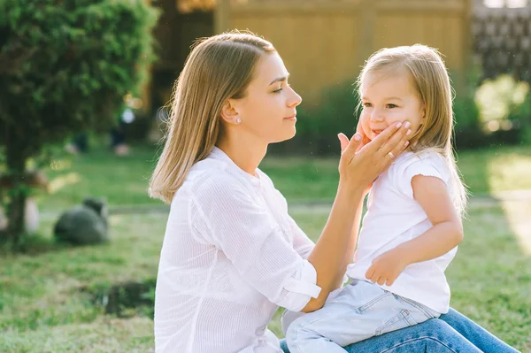 Side view of mother and little daughter on backyard — Stock Photo