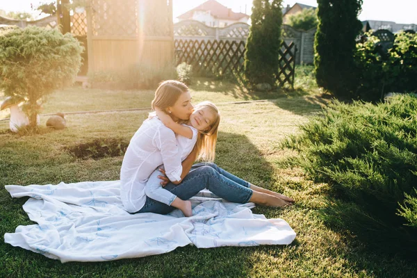Side view of family resting on cloth on ground together on backyard — Stock Photo