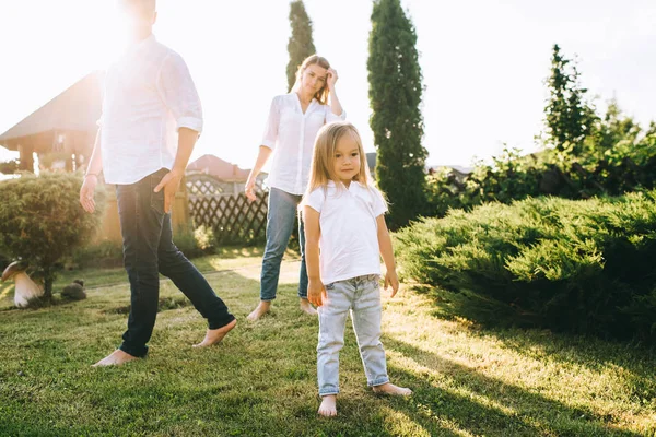 Foyer sélectif du petit enfant avec des parents derrière sur la cour arrière — Photo de stock