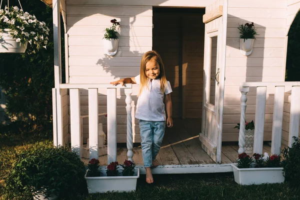 Criança de pé na varanda da casa de campo sozinha no dia de verão — Fotografia de Stock