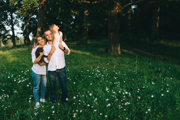 Lächelnde Eltern mit Tochter und kleinem Labrador-Welpen im Wald — Stockfoto