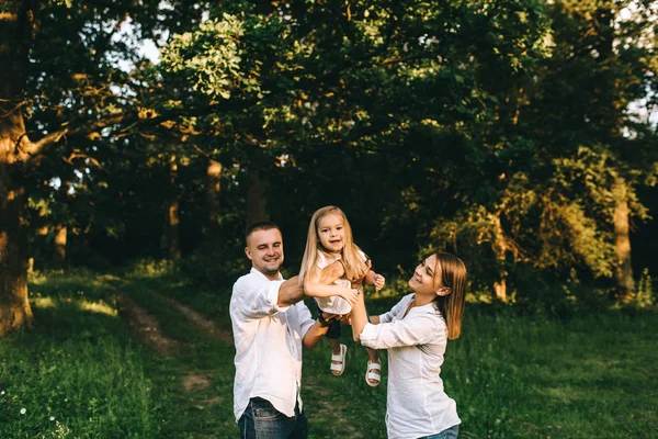 Портрет семьи, веселящихся вместе в лесу в летний день — стоковое фото