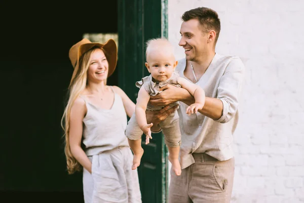 Portrait of happy parents with cute little son in village — Stock Photo