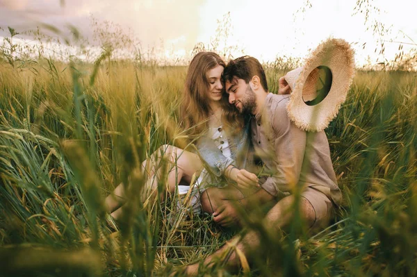 Hermosa pareja elegante abrazándose en la hierba verde en el prado - foto de stock
