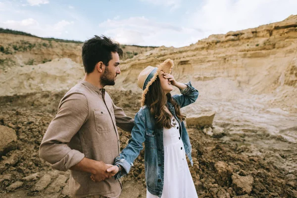 Laughing girl closing eyes and holding hands with in sand canyon — Stock Photo