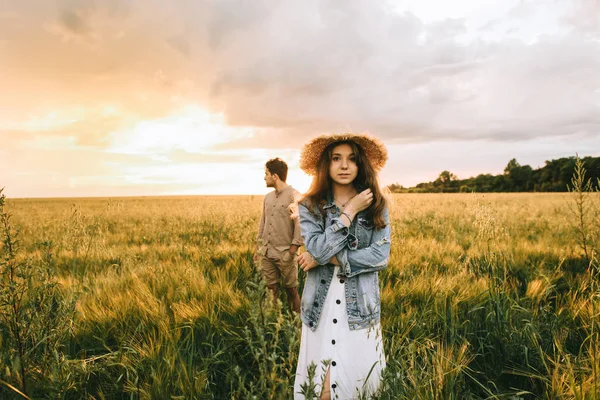 Stylish couple posing on meadow with back light — Stock Photo