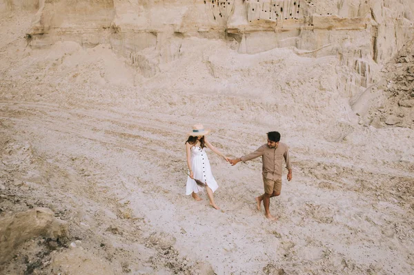 High angle view of couple holding hands and walking in sand canyon — Stock Photo