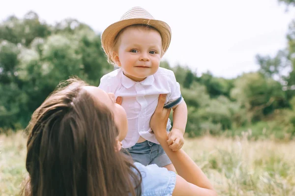 Glückliche Mutter hält stylisches Baby in den Händen — Stockfoto