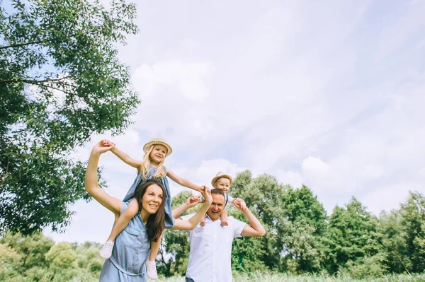 Feliz madre y padre a cuestas hijo e hija y pasar tiempo juntos - foto de stock