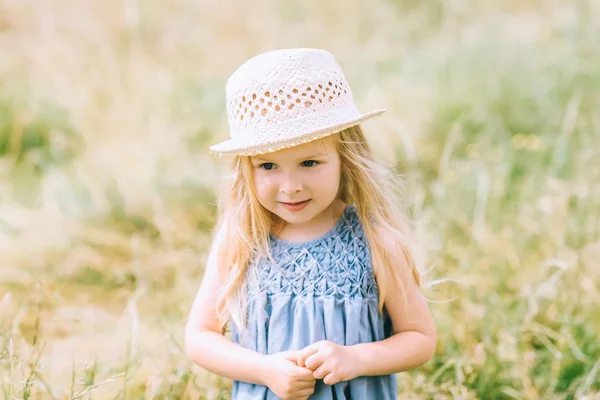 Adorable blonde child in dress and straw hat — Stock Photo