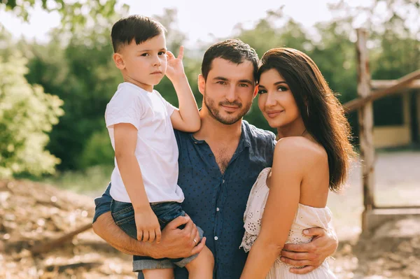 Portrait of parents and son looking at camera outdoors — Stock Photo