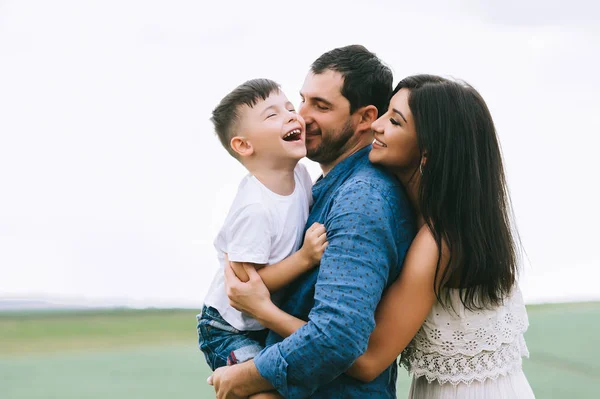 Genitori sorridenti e figlio divertirsi sul campo — Foto stock