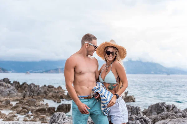 Novia sonriente y novio de pie en la playa en Montenegro - foto de stock