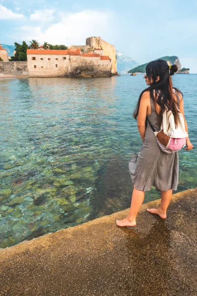 Donna in piedi sul molo con Stari Grad (Città Vecchia) sullo sfondo a Budva, Montenegro — Foto stock