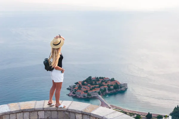 Mujer de pie y mirando la isla de San Esteban en el mar Adriático, Budva, Montenegro — Stock Photo