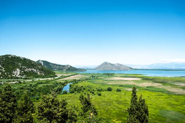 Hermosa vista del valle verde, lago y montañas en Montenegro - foto de stock