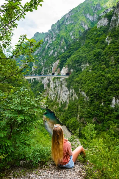 Vue arrière de la femme regardant le pont entre les montagnes au-dessus de la rivière Piva dans le canyon de Piva au Monténégro — Photo de stock