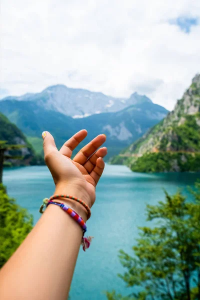 Geschnittenes Bild einer Frau, die die Hand nach dem schönen Piva-See (Pivsko jezero) in Montenegro ausstreckt — Stockfoto