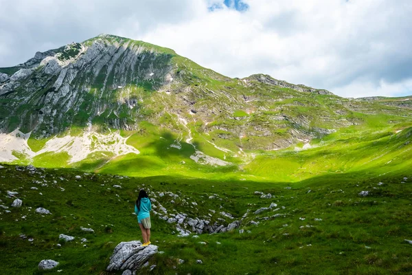 Резервного зору жінка, стоячи на камінь і, дивлячись на гори в Дурмітор масиву, Чорногорія — стокове фото