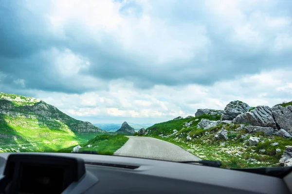 Carro na estrada da montanha com céu nublado em Durmitor maciço, Montenegro — Fotografia de Stock
