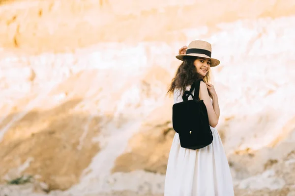 Красива усміхнена дівчина в соломі з рюкзаком в піщаному каньйоні — стокове фото