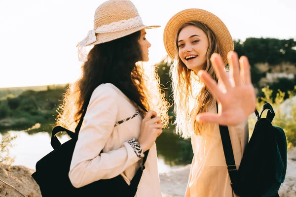 Belas namoradas felizes em chapéus de palha passar tempo juntos — Fotografia de Stock