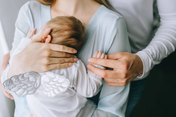 Image recadrée de la famille portant un petit garçon avec des ailes à la maison — Photo de stock