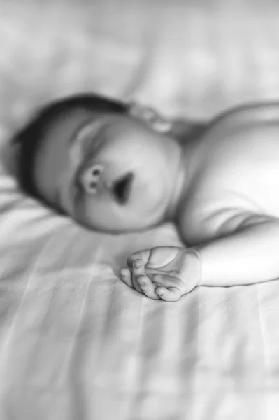 Foyer sélectif de mignon petit garçon dormant dans le lit à la maison, noir et blanc — Photo de stock