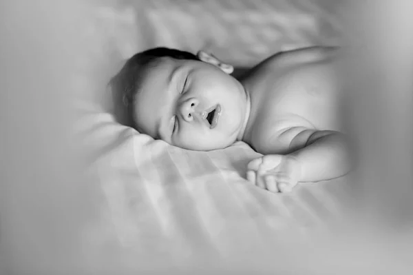 Foto en blanco y negro de lindo bebé niño durmiendo en la cama en casa - foto de stock