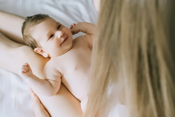 Partial view of mother playing with adorable baby boy in bed at home — Stock Photo