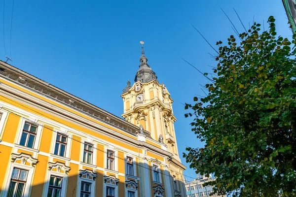 Cluj-Napoca City Hall  on a sunny summer day with blue sky in Romania. It features a Viennese baroque facade with a corner clock tower — Stock Photo, Image
